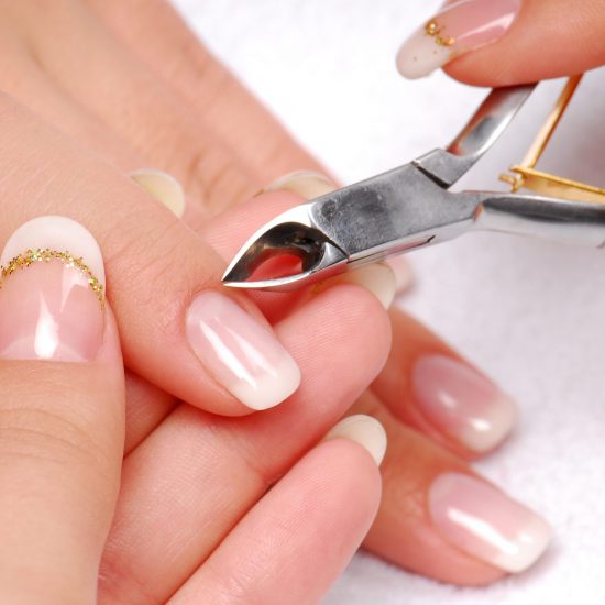 Nail salon - Cut cuticle on the female forefinger